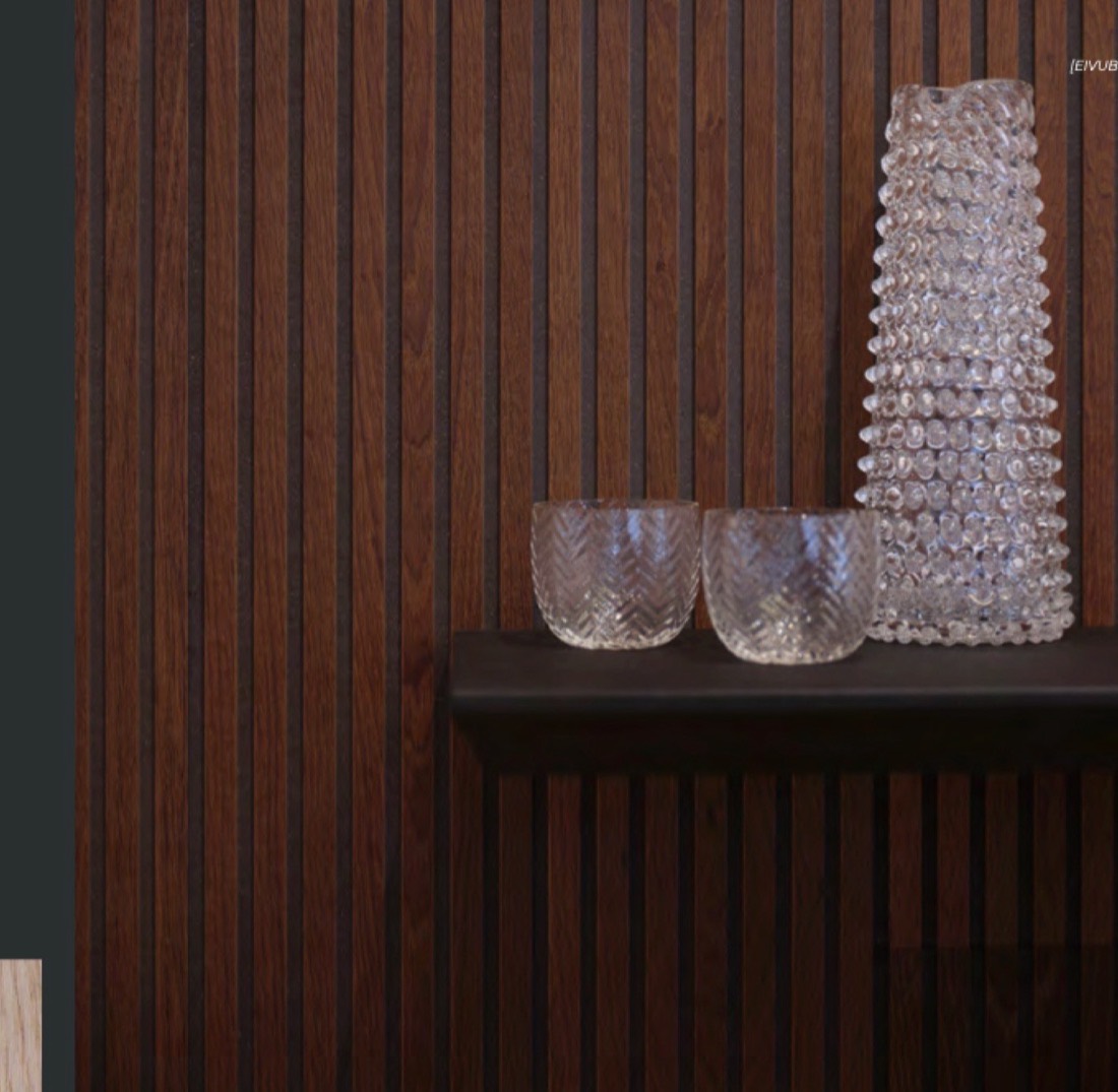Parete rivestita con Boiserie Mafi in legno scuro e mensola con vasi